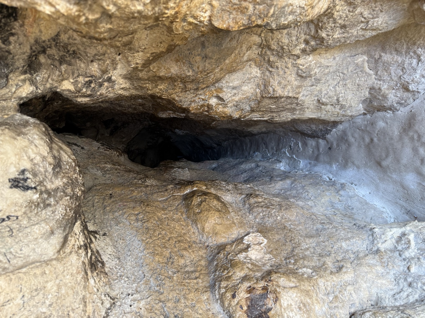 山洞岩缝入口，黑暗中延伸的石道