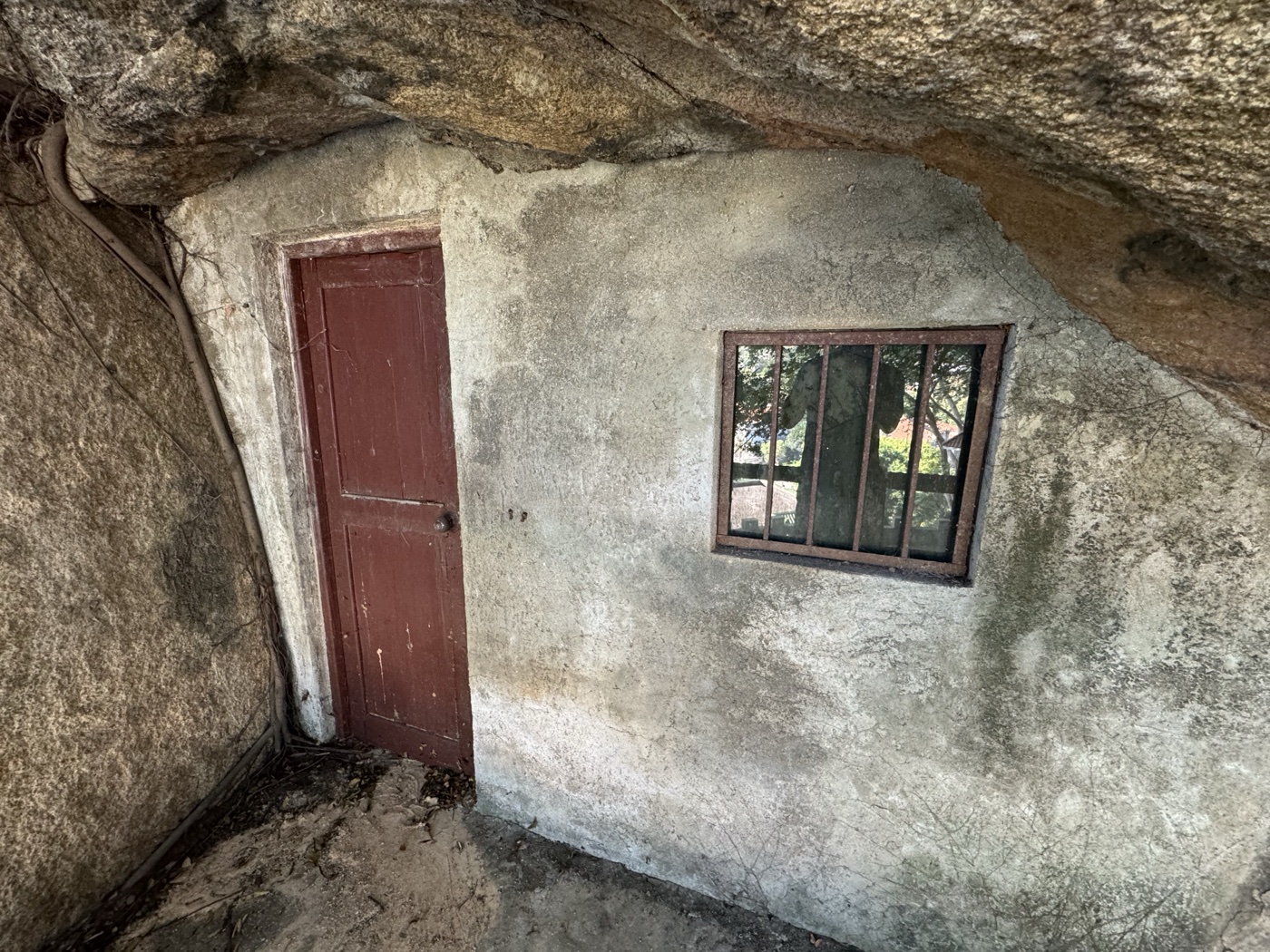 弘一法师修行山洞，红色木门嵌入岩壁